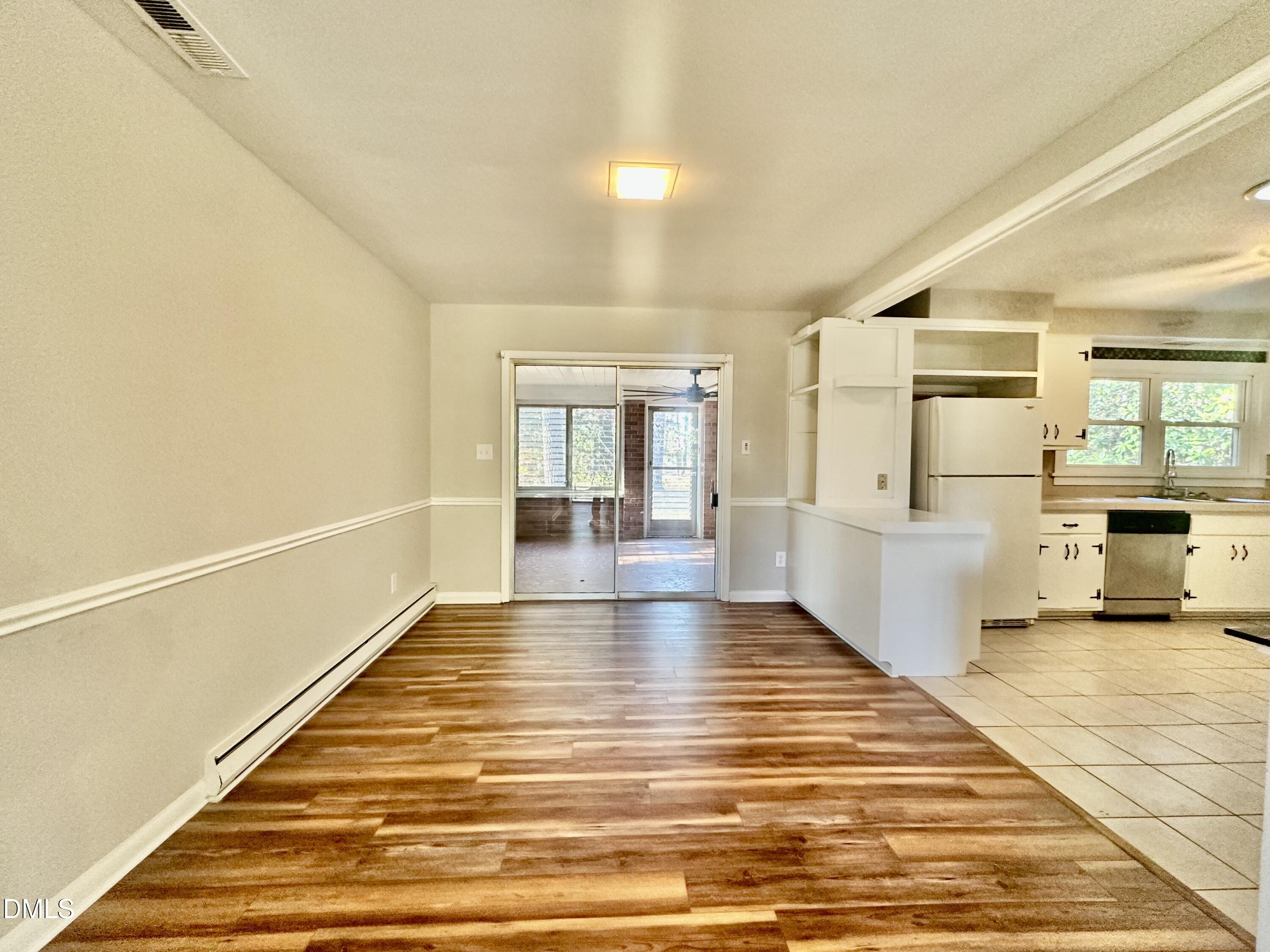 405 North Main Street Wake Forest, NC 27587 - Photo 7 of 21 a view of a living room with kitchen island stainless steel appliances wooden floor and window