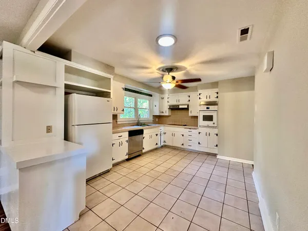 a kitchen with stainless steel appliances a refrigerator and a stove top oven