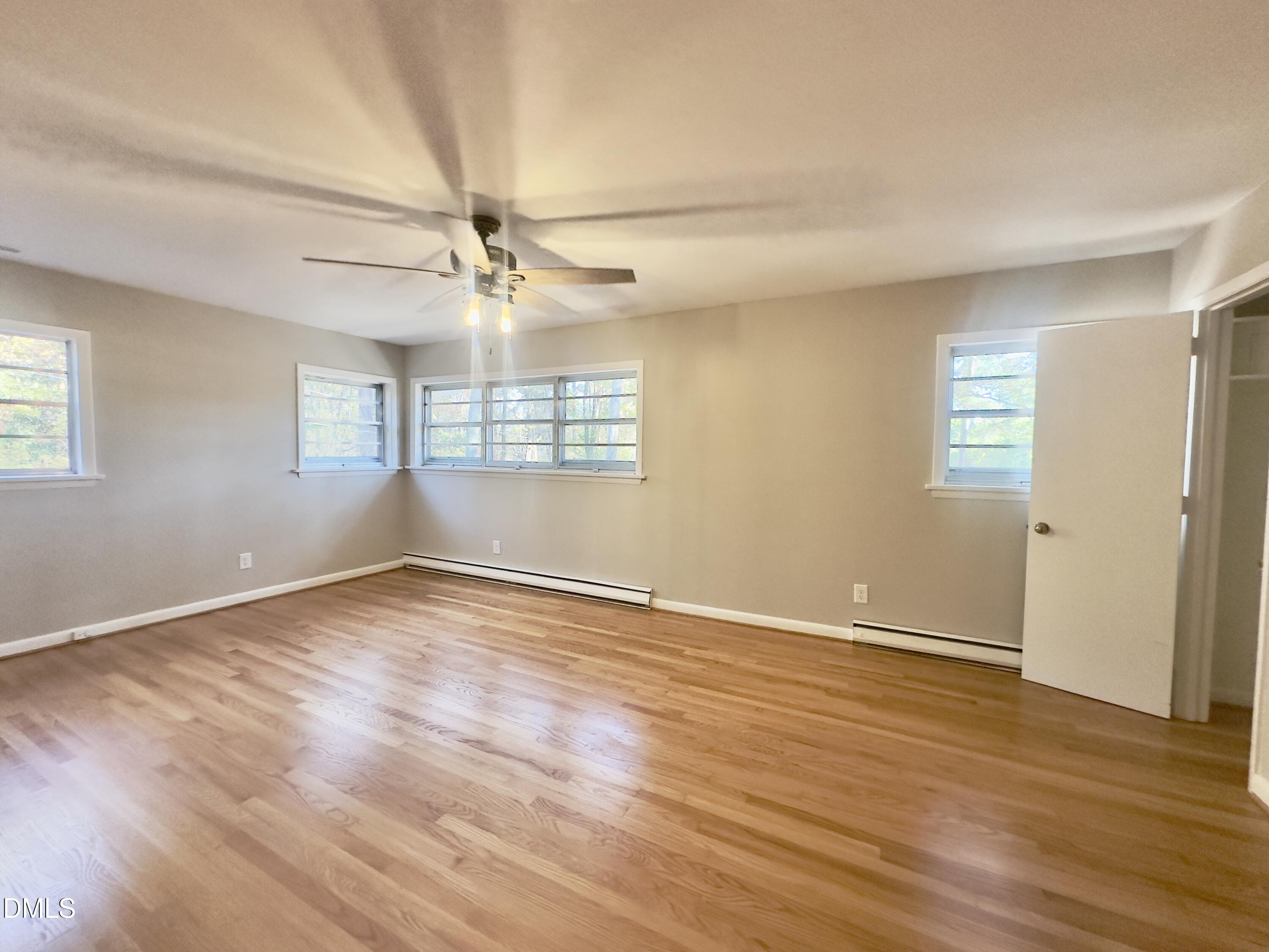 405 North Main Street Wake Forest, NC 27587 - Photo 10 of 21 an empty room with wooden floor fan and windows