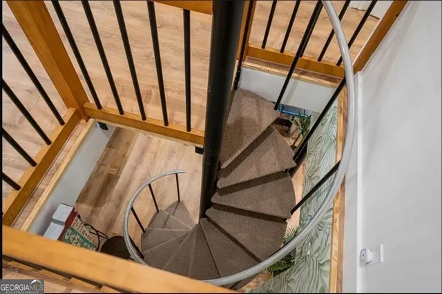 a view of staircase with wooden floor and white walls