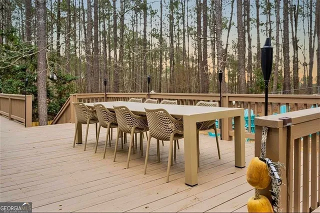 a view of a patio with table and chairs with wooden floor and fence