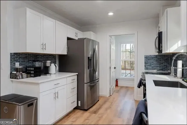 a kitchen with stainless steel appliances a refrigerator sink and cabinets