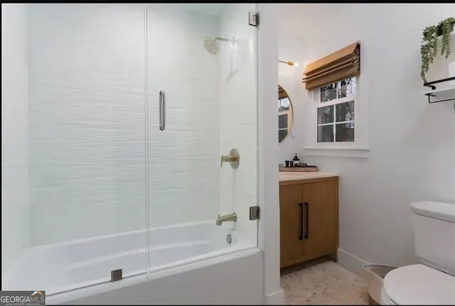 a bathroom with a granite countertop toilet sink and shower