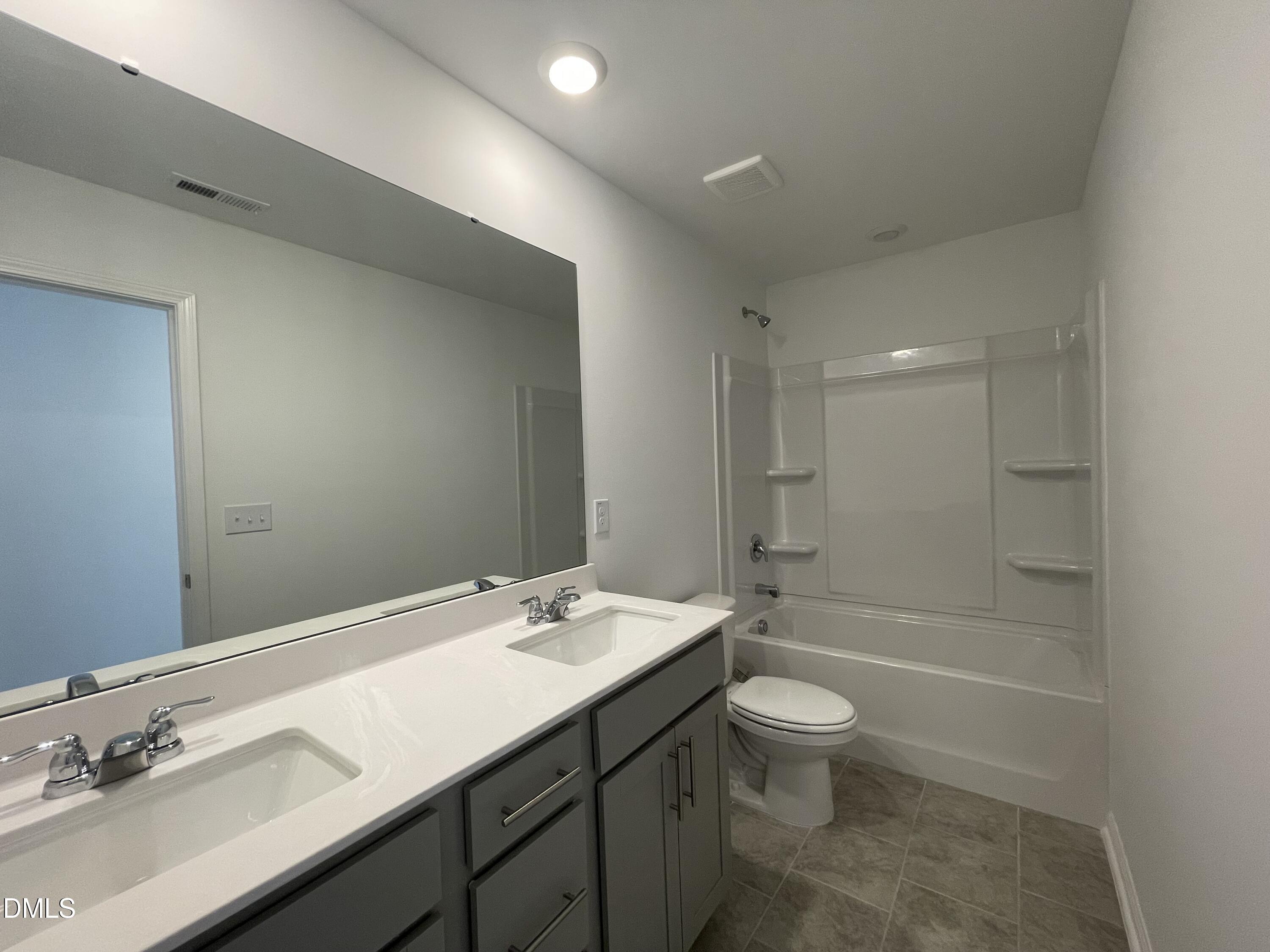 66 Digging Time Avenue Princeton, NC 27569 - Photo 13 of 47 a bathroom with a double vanity sink toilet mirror and shower