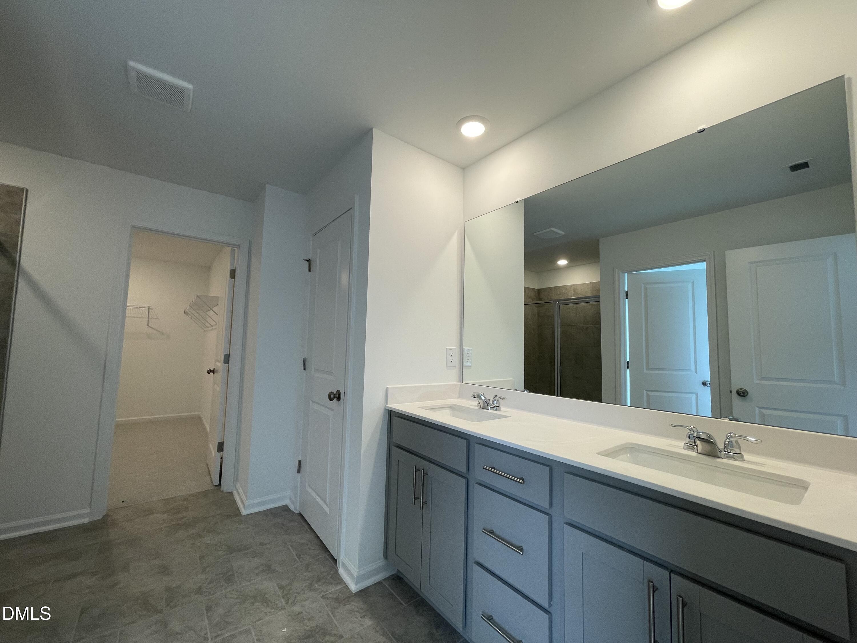 66 Digging Time Avenue Princeton, NC 27569 - Photo 17 of 47 a bathroom with a double vanity sink and mirror