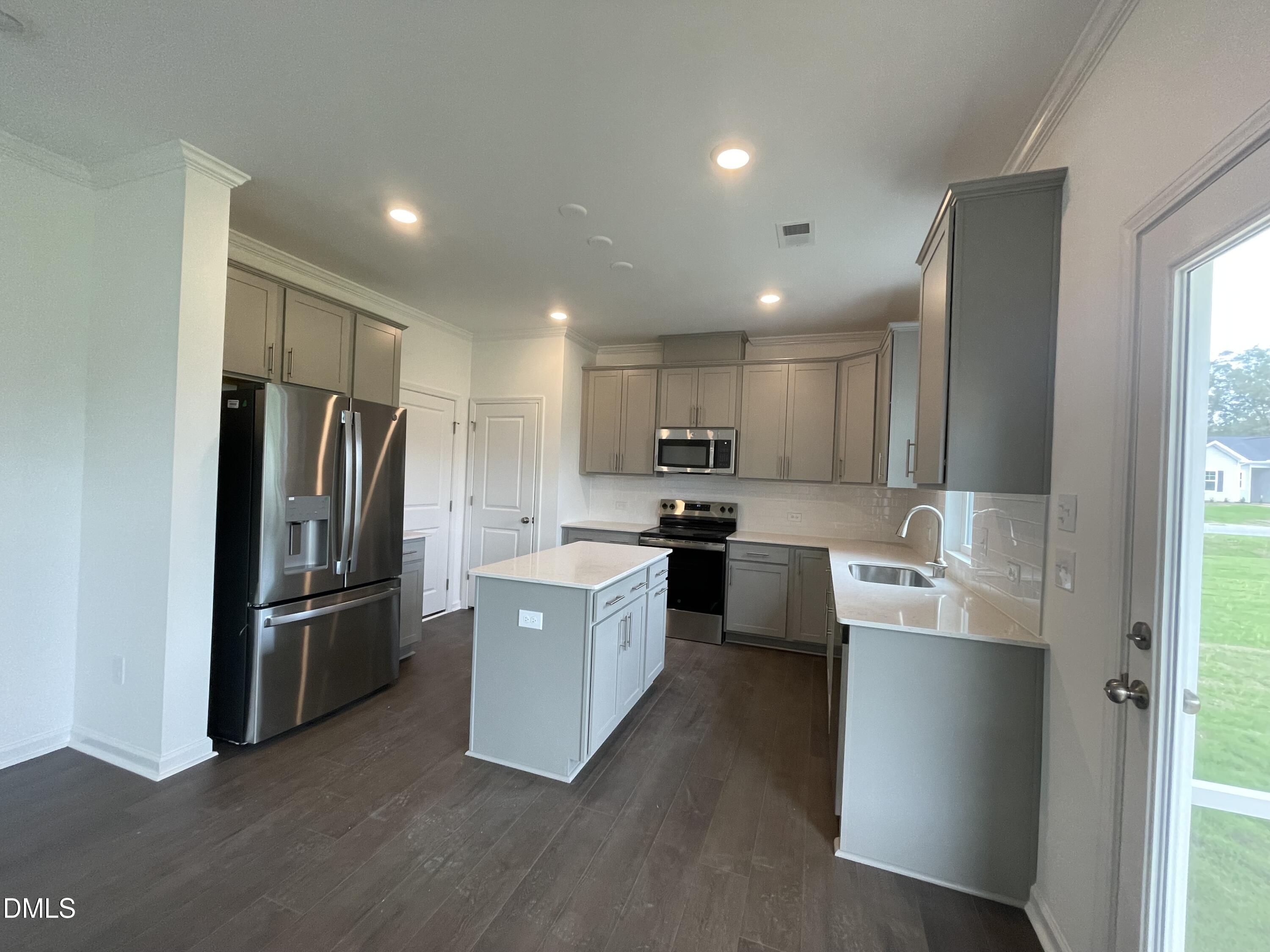 66 Digging Time Avenue Princeton, NC 27569 - Photo 4 of 47 a large kitchen with stainless steel appliances a refrigerator a sink dishwasher a oven with white cabinets and wooden floor