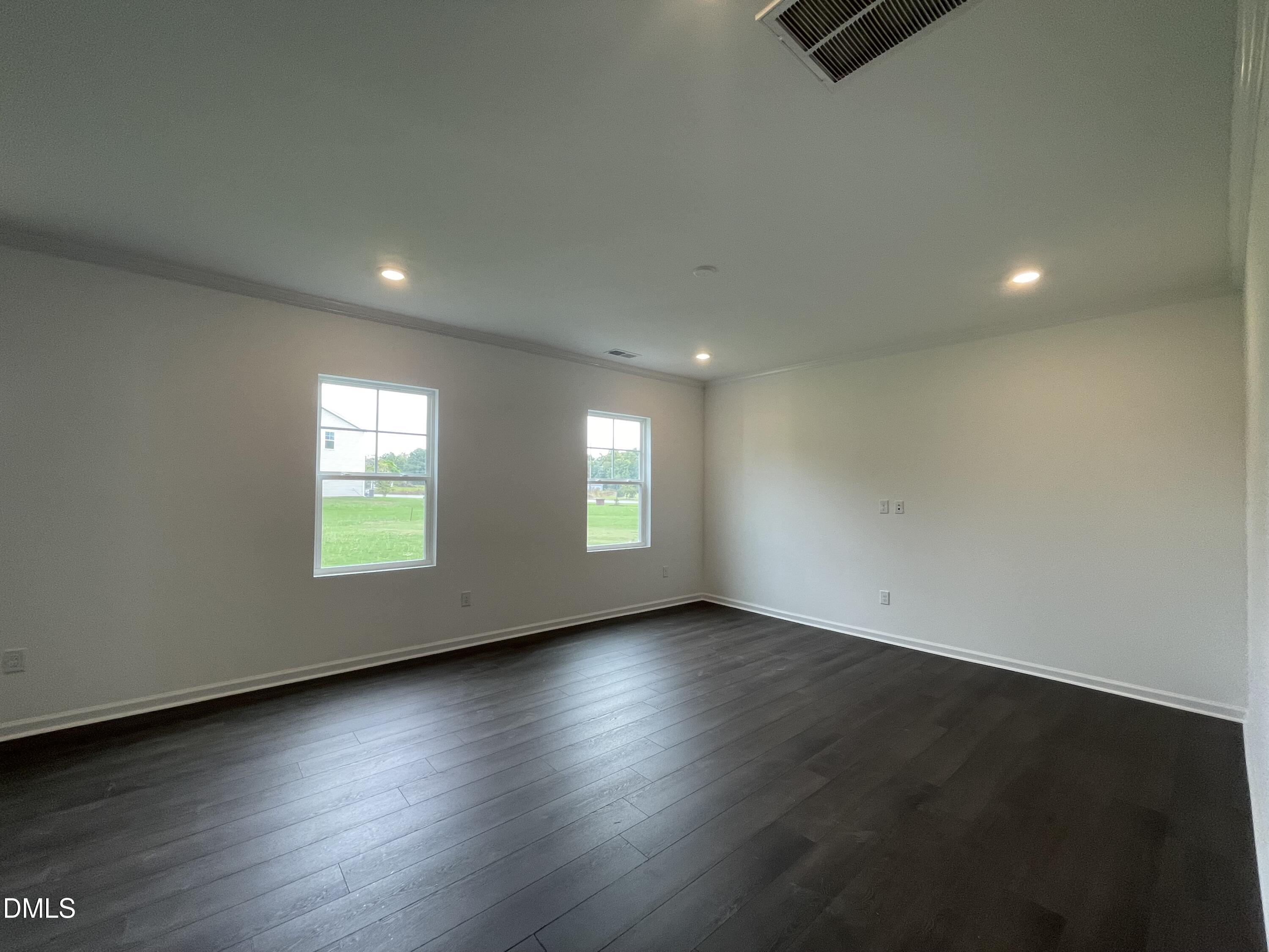 66 Digging Time Avenue Princeton, NC 27569 - Photo 5 of 47 an empty room with wooden floor and windows