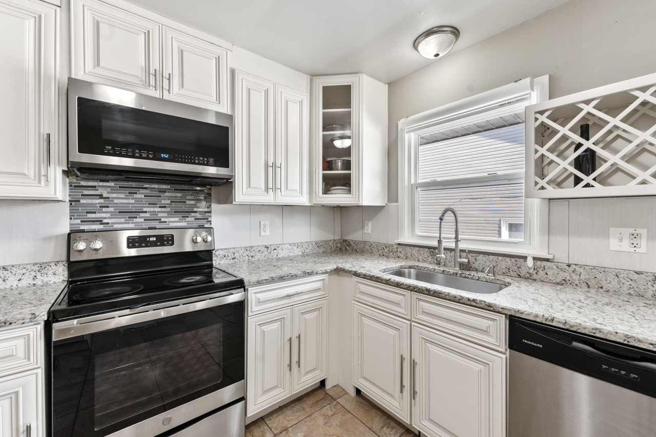 727 Lacy Avenue Streamwood, IL 60107 - Photo 13 of 30 a kitchen with granite countertop a stove microwave and sink