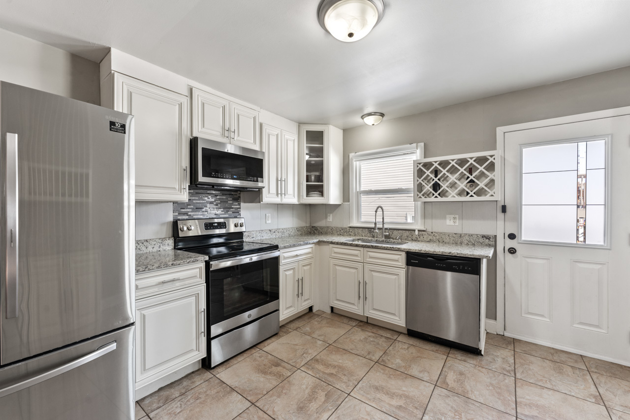 727 Lacy Avenue Streamwood, IL 60107 - Photo 10 of 30 a kitchen with granite countertop a stove top oven microwave and cabinets