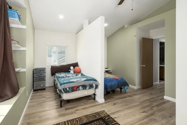 a bedroom with a bed and wooden floor