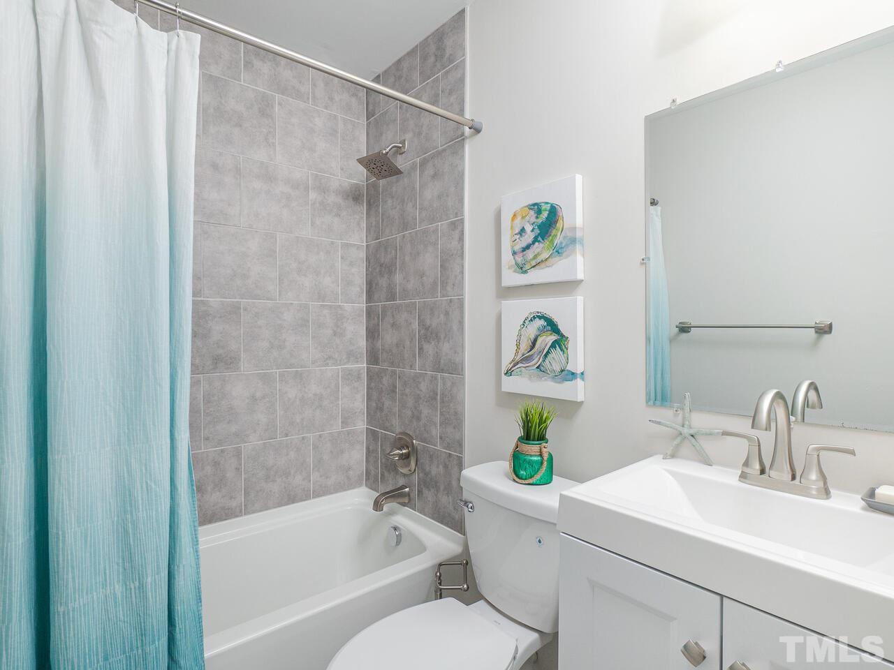 1507 Pender Street Raleigh, NC 27610 - Photo 16 of 30 a bathroom with a sink a bathtub and a shower