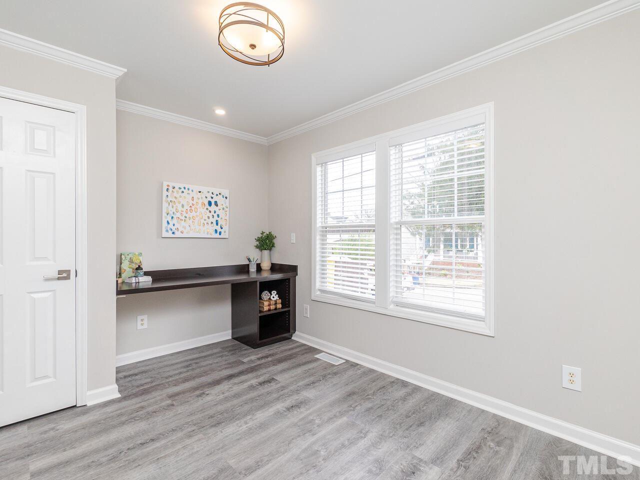 1507 Pender Street Raleigh, NC 27610 - Photo 3 of 30 an empty room with wooden floor cabinet and windows