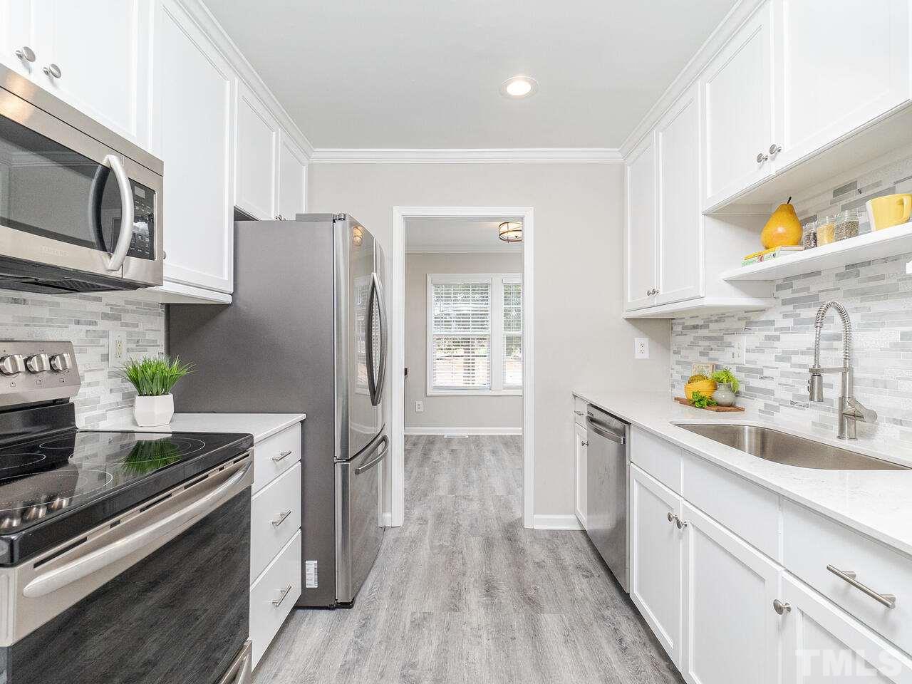 1507 Pender Street Raleigh, NC 27610 - Photo 9 of 30 a kitchen with stainless steel appliances a stove microwave and cabinets