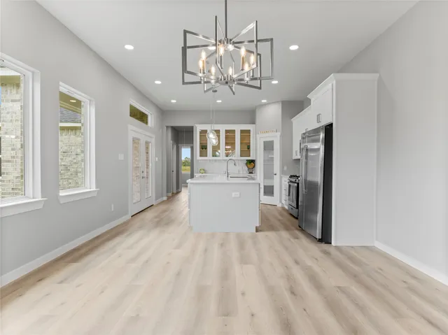 a view of a kitchen with refrigerator and windows
