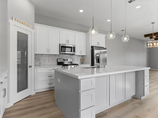 a kitchen with white cabinets and stainless steel appliances