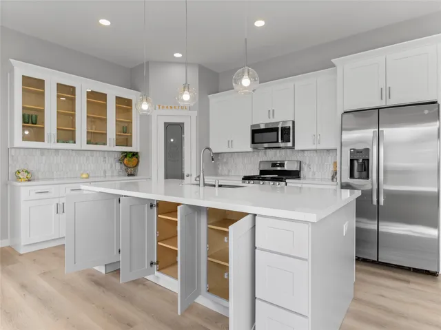 a kitchen with white cabinets and stainless steel appliances