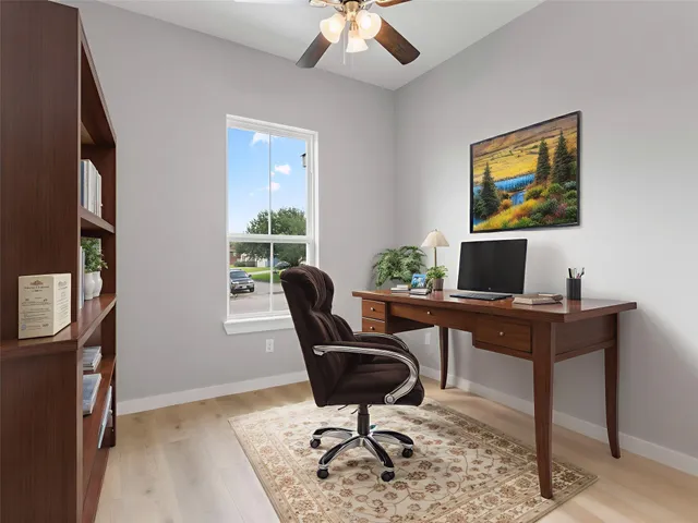 a view of a workspace with furniture and a window