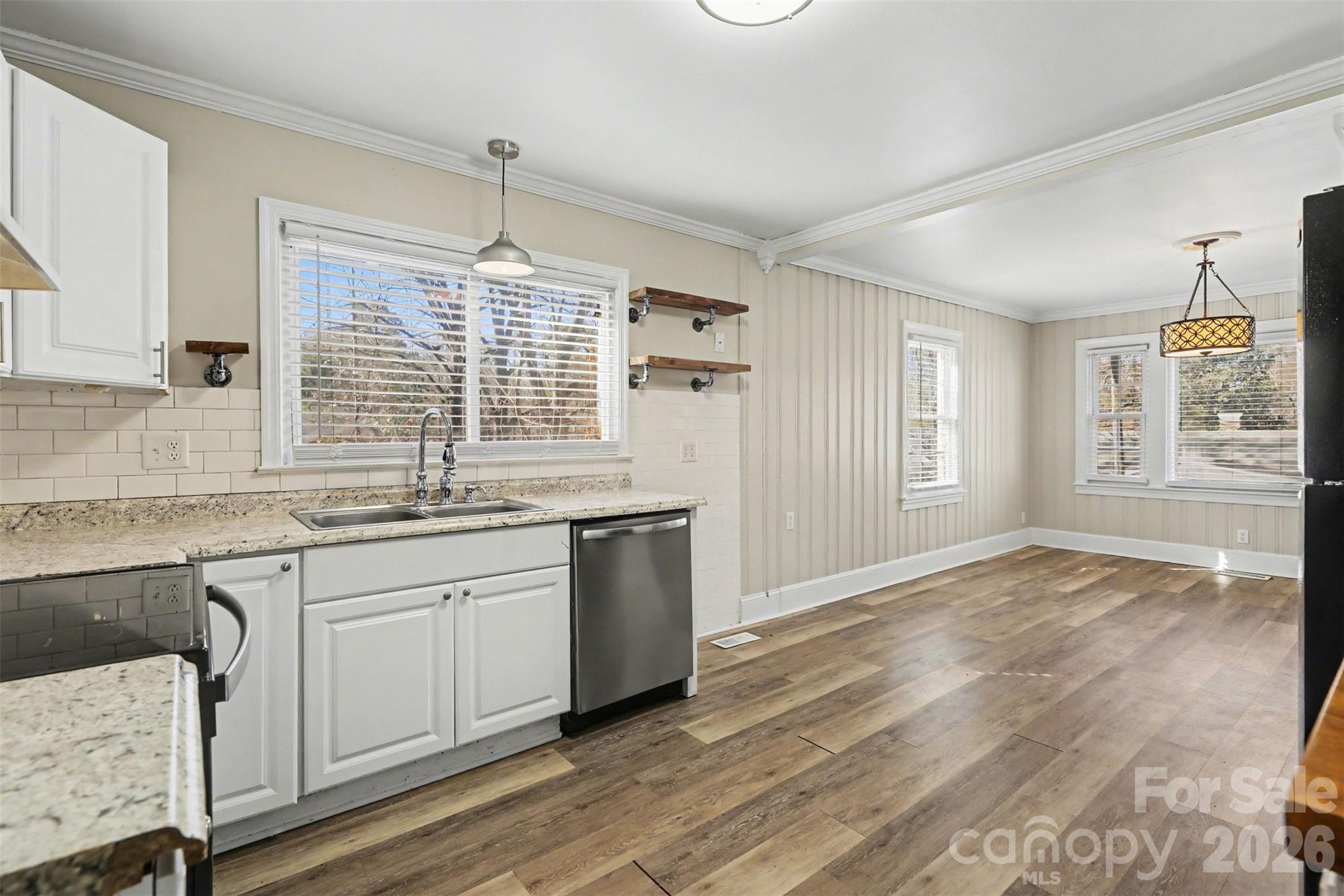 614 North Rhyne Street Gastonia, NC 28054 - Photo 13 of 29 a kitchen with granite countertop a stove a sink and white cabinets with wooden floor