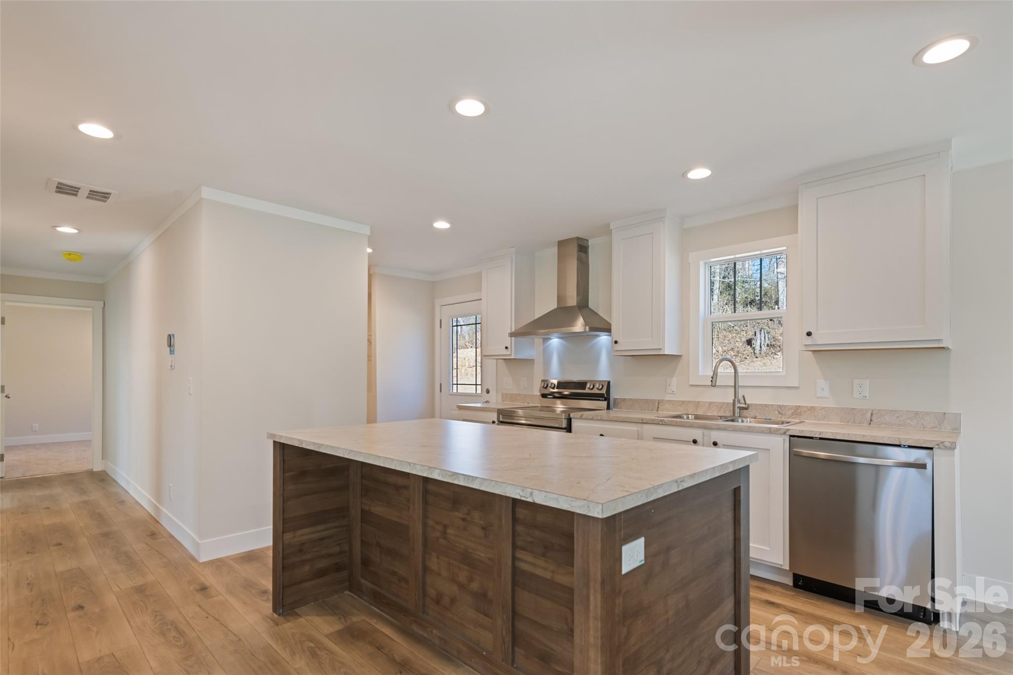 77 Geiranger Drive Clyde, NC 28721 - Photo 5 of 29 a kitchen with a sink a stove a refrigerator and white cabinets