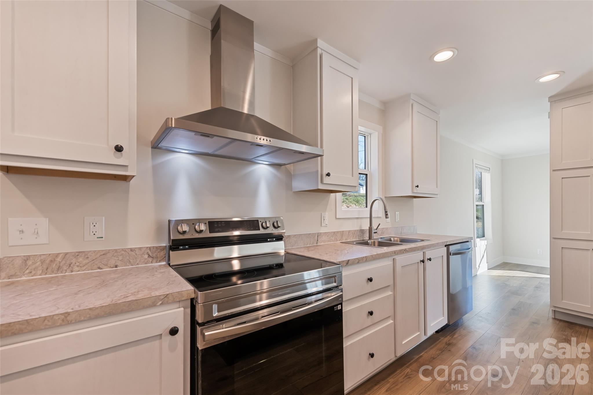 77 Geiranger Drive Clyde, NC 28721 - Photo 9 of 29 a kitchen with stainless steel appliances a stove and white cabinets