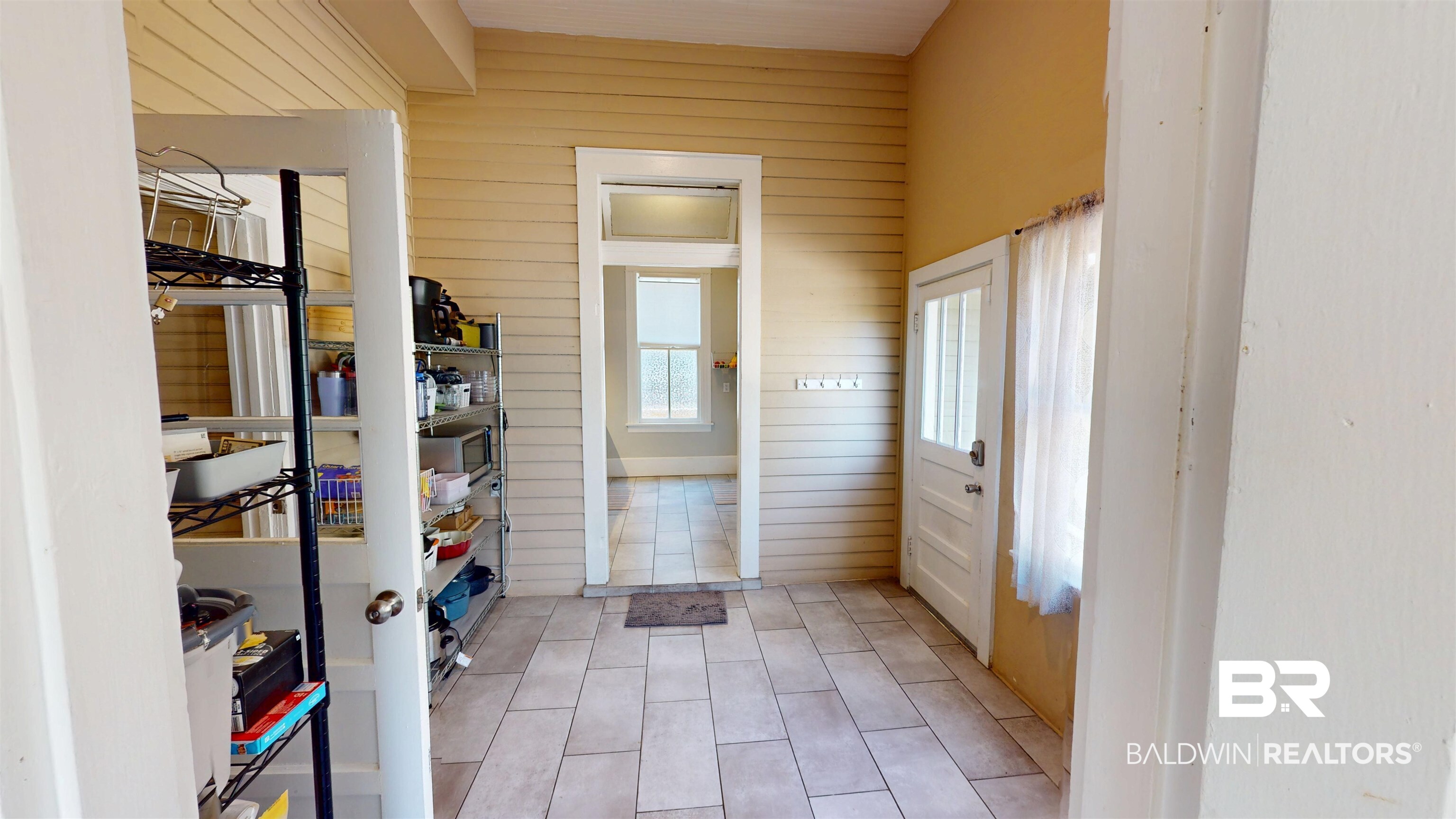 1154 New St Francis Street Mobile, AL 36604 - Photo 17 of 37 Doorway to outside with light tile patterned floors and wooden walls