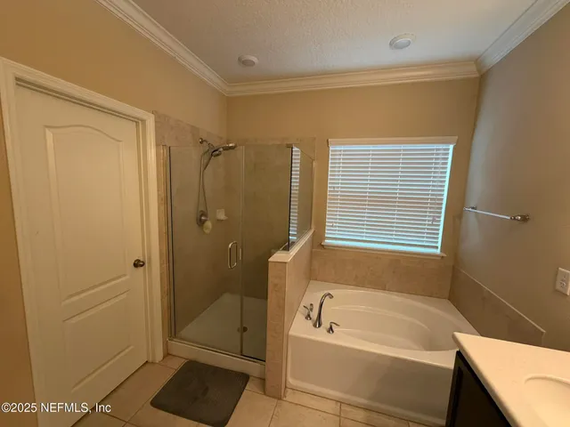 a bathroom with a tub a sink and shower