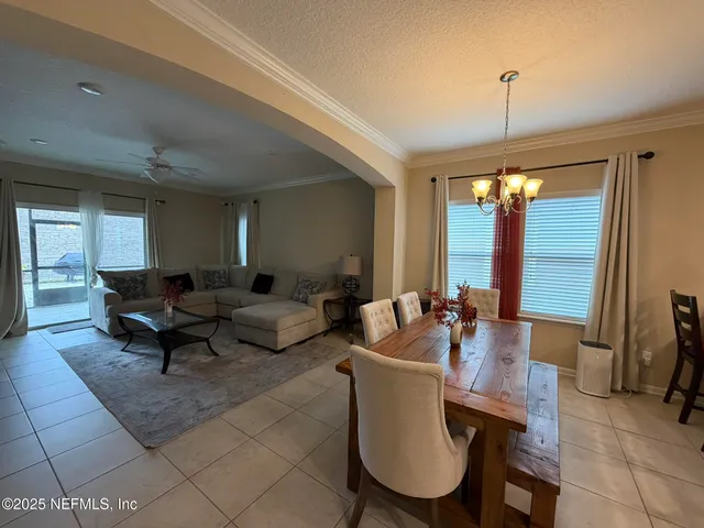 a living room with furniture a large window and a chandelier
