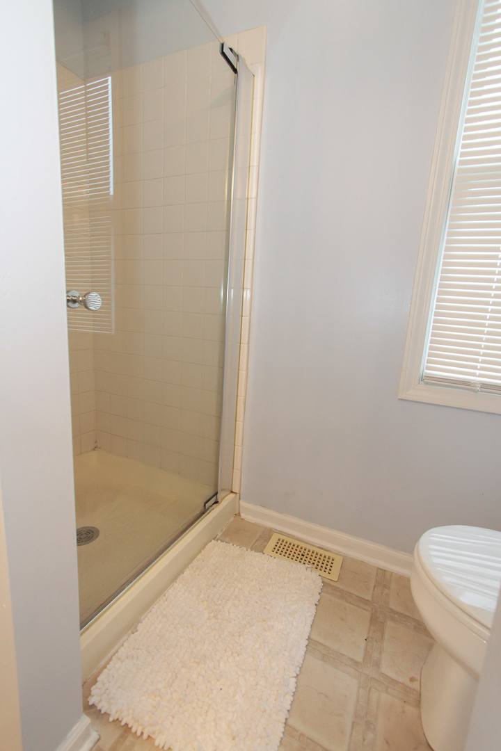 1474 Knotty Pine Drive Elgin, IL 60123 - Photo 13 of 21 a bathroom with a granite countertop toilet and a shower