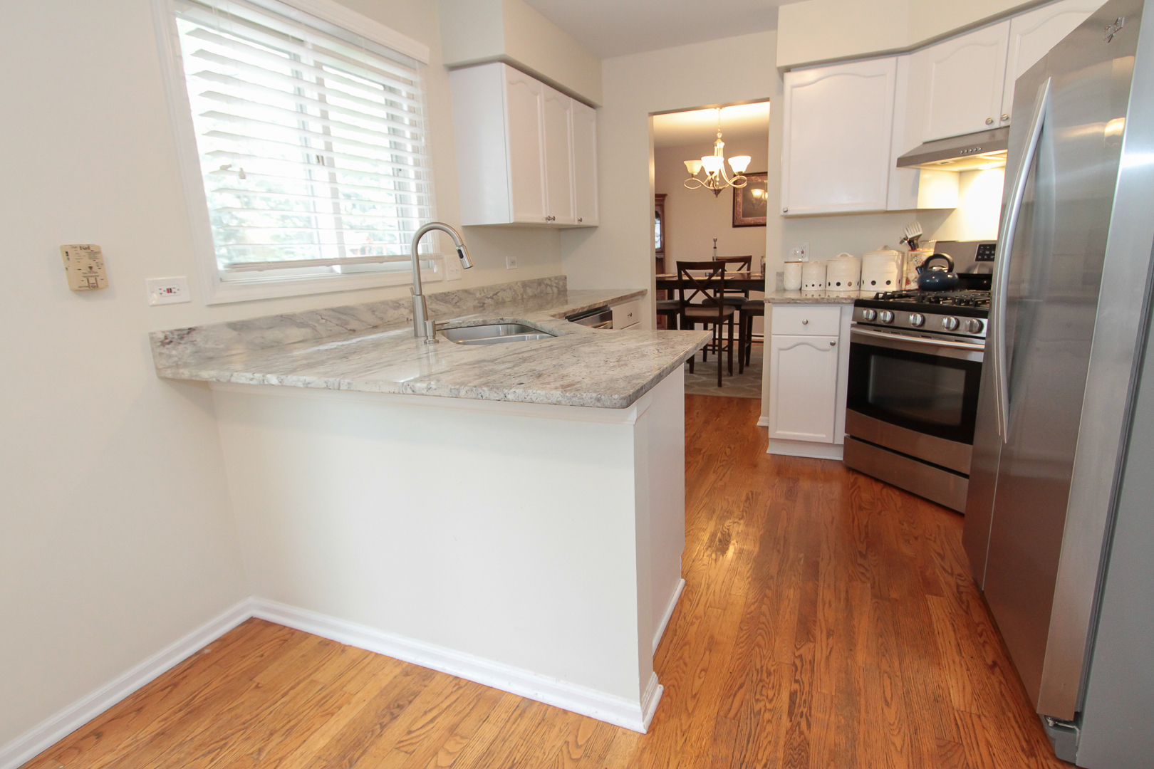 1474 Knotty Pine Drive Elgin, IL 60123 - Photo 6 of 21 a kitchen with stainless steel appliances granite countertop a sink a stove a refrigerator and wooden floor