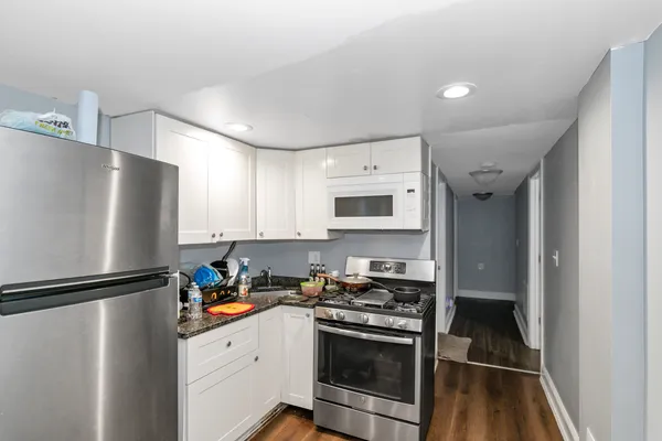 a kitchen with stainless steel appliances granite countertop a refrigerator sink and stove