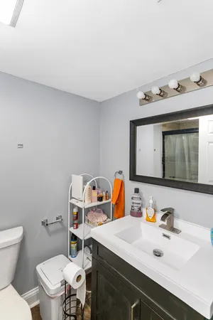 a bathroom with a toilet sink and mirror