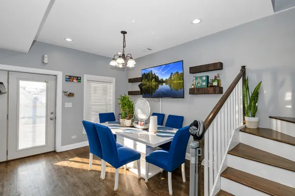 a view of a dining room with furniture a chandelier and wooden floor