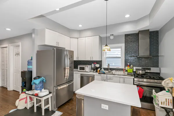 a kitchen with a refrigerator a stove a sink and chairs