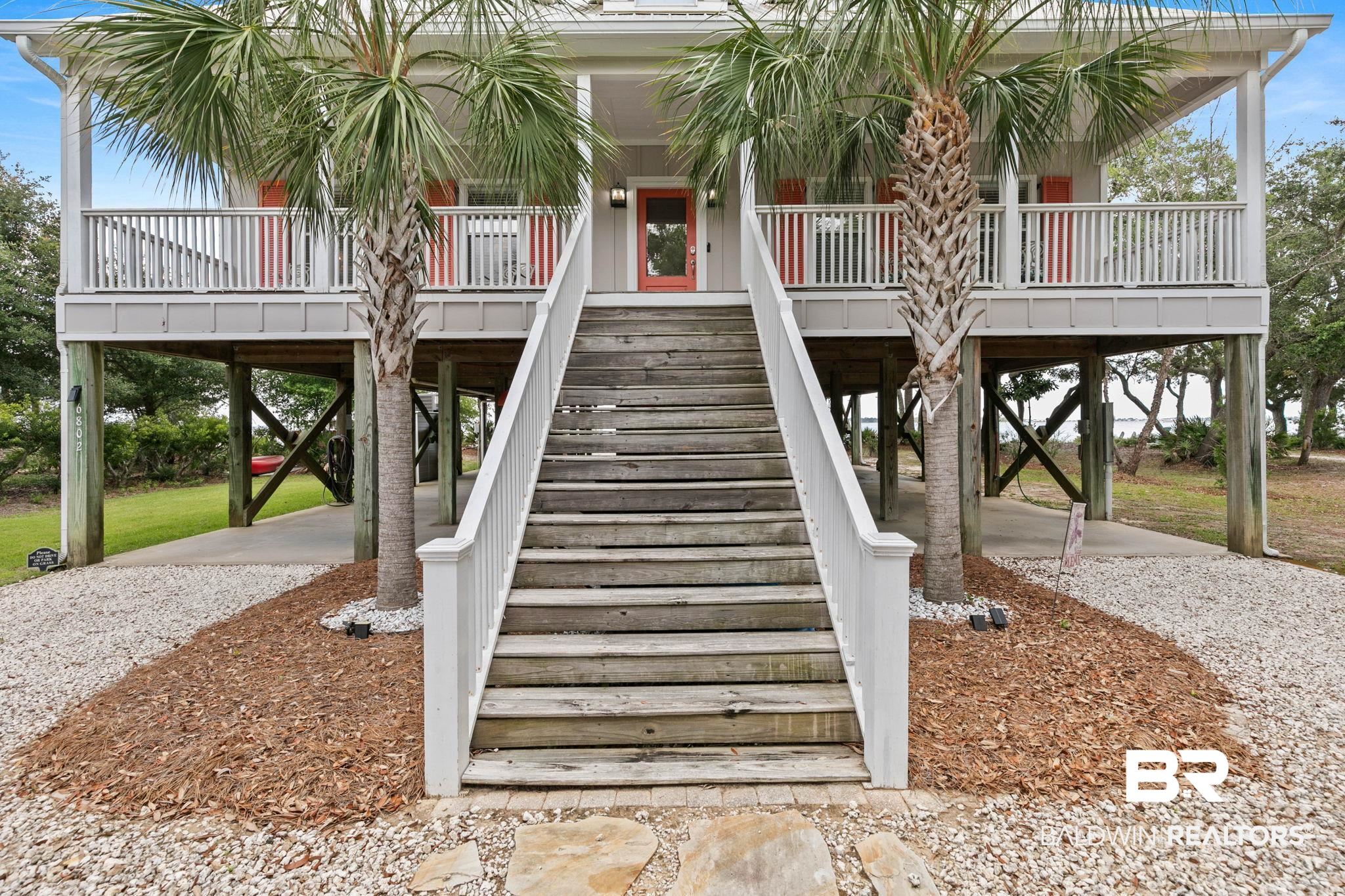 6802 Shore Drive Elberta, AL 36530 - Photo 3 of 34 Elevated coastal residence featuring a prominent wooden staircase and a deep front porch