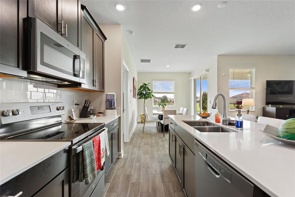 a kitchen with lots of counter top space a sink appliances and cabinets