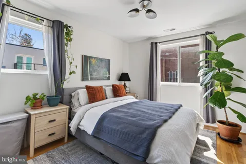 a bedroom with a bed potted plant with the outer view
