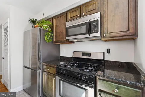 a kitchen with stainless steel appliances granite countertop a stove and a microwave
