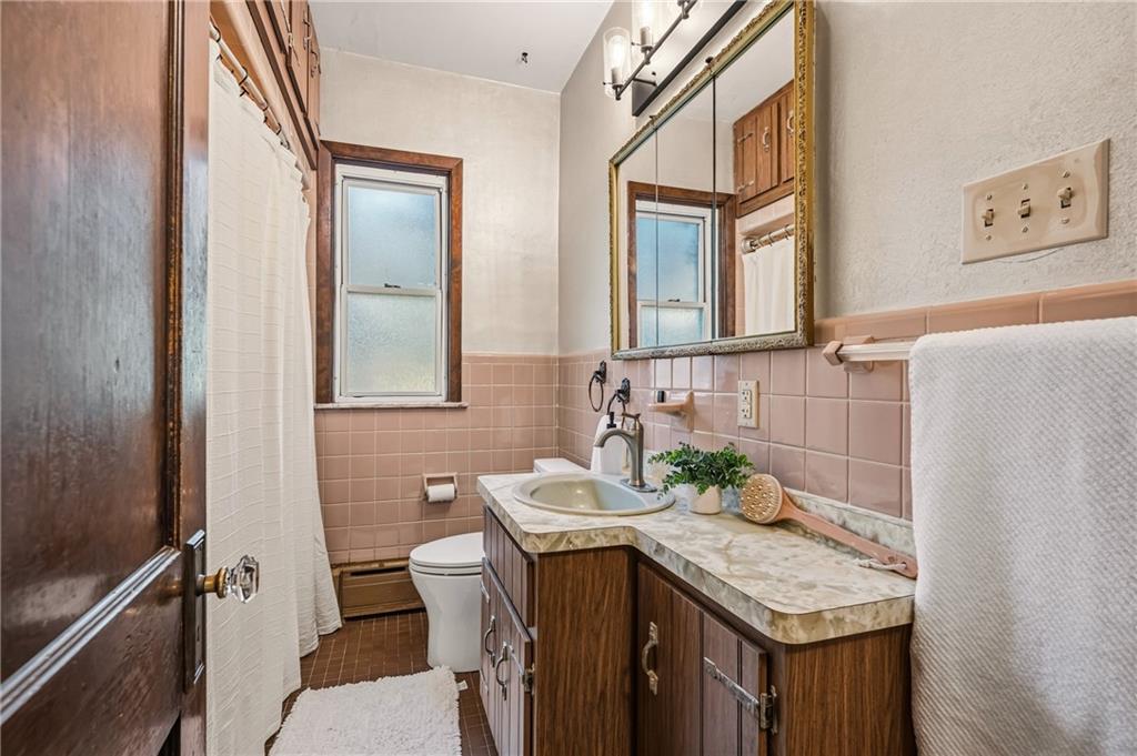 218 Elmore Road Pittsburgh, PA 15221 - Photo 14 of 34 Classic tile bathroom with a custom vanity and a large mirror.
