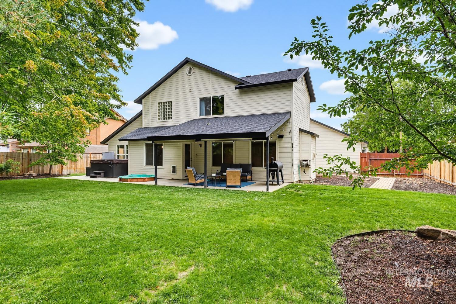 369 South Winthrop Way Boise, ID 83709 - Photo 41 of 50 Expansive backyard featuring a manicured lawn, a concrete patio with a covered section, a built-in hot tub, and a separate spa