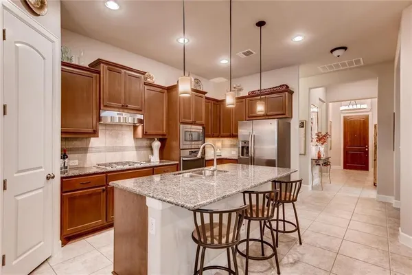 a kitchen with stainless steel appliances granite countertop a sink stove and refrigerator