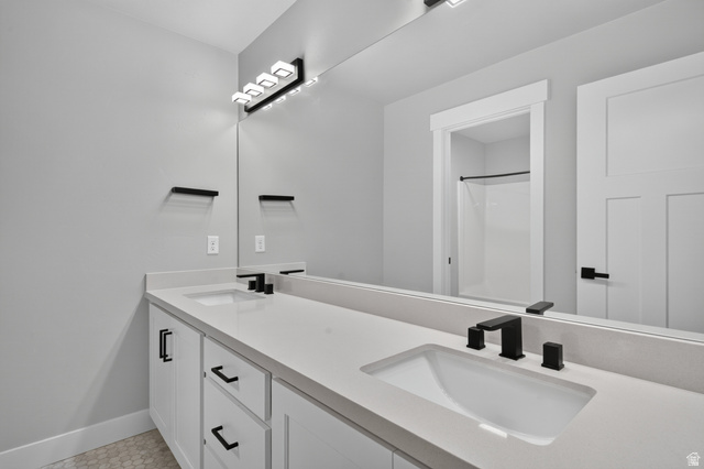 36 West Syracuse Road Vineyard, UT 84059 - Photo 40 of 56 Spacious bathroom featuring a dual vanity with white cabinetry, light-toned countertops, and integrated rectangular sinks