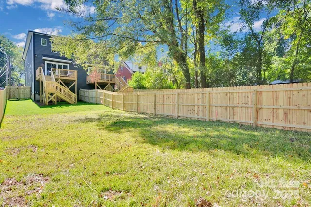 a view of backyard with table and chairs and wooden fence