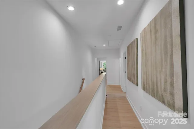 a view of a hallway with wooden floor and staircase