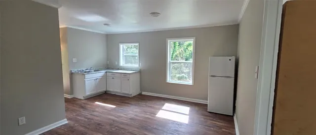 a view of a kitchen with a sink a refrigerator and window