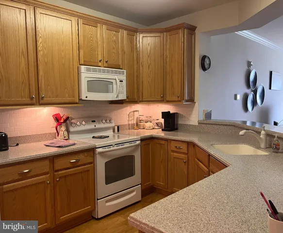 a kitchen with granite countertop a sink stainless steel appliances and cabinets