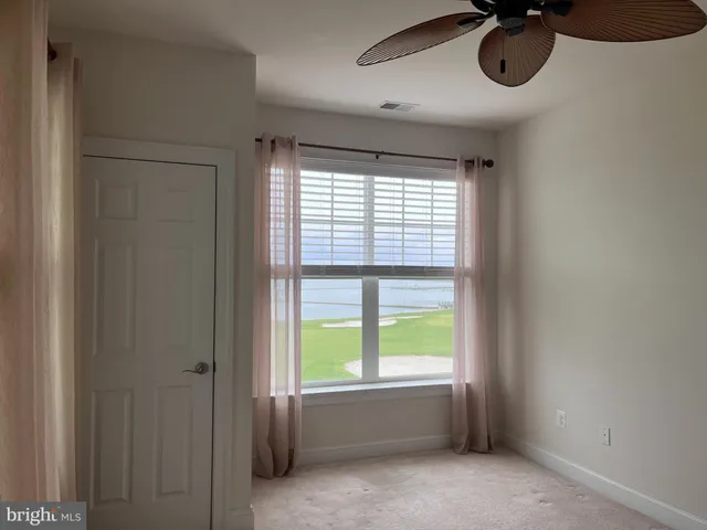 a room with window closet chandelier fan and windows