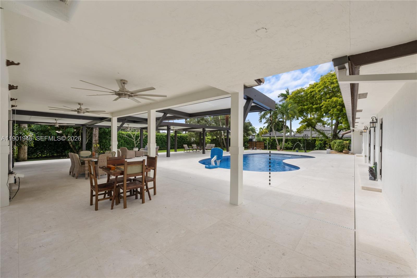 15110 North Saxon Circle Southwest Ranches, FL 33331 - Photo 34 of 45 a view of a patio with table and chairs potted plants with floor to ceiling window