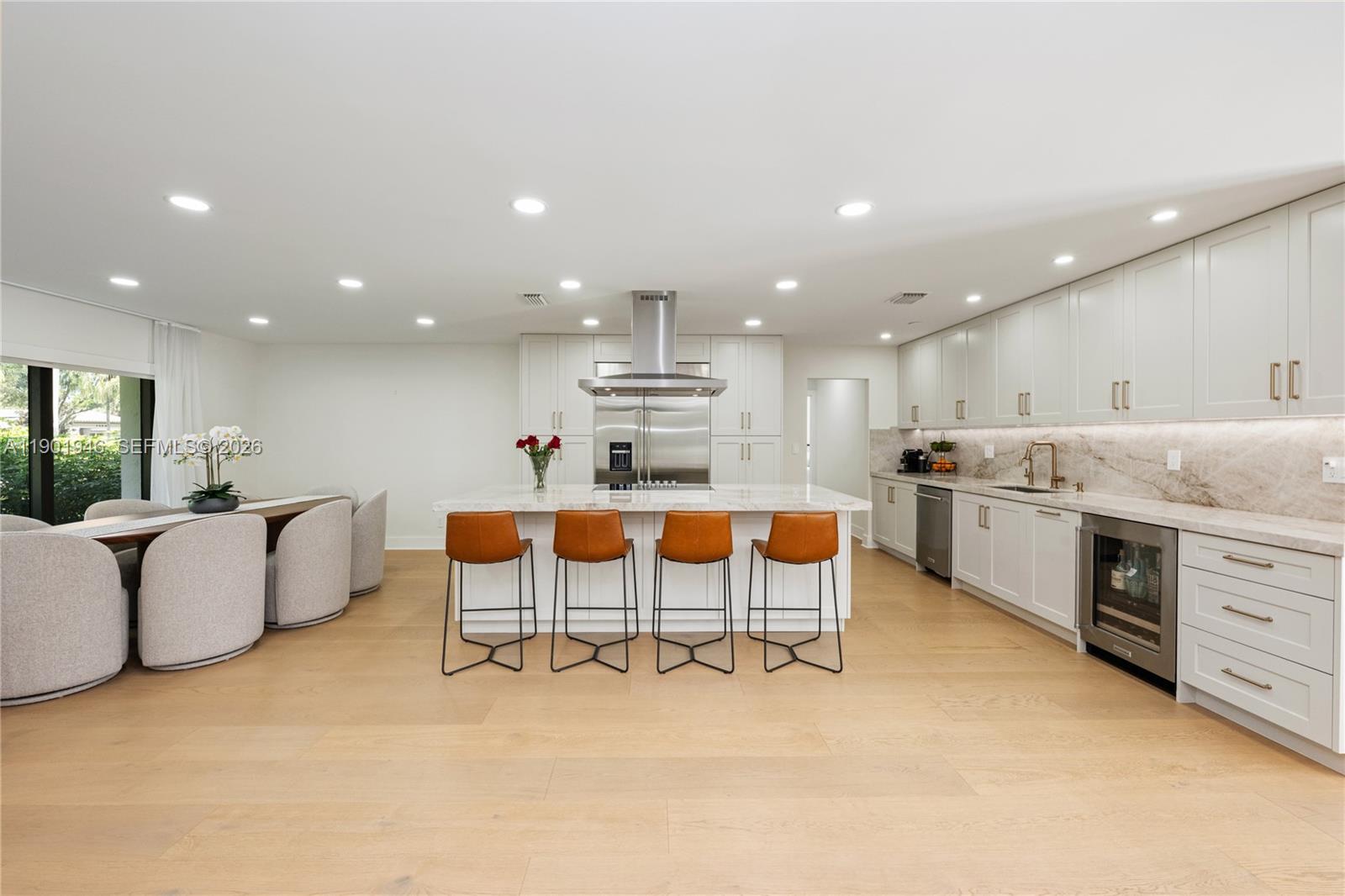 15110 North Saxon Circle Southwest Ranches, FL 33331 - Photo 5 of 45 a large white kitchen with stainless steel appliances kitchen island granite countertop a table and chairs in it
