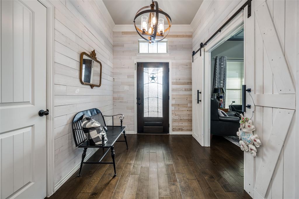 7417 Green Mesa Road Ponder, TX 76259 - Photo 4 of 39 a view of a hallway with wooden floor and a chandelier