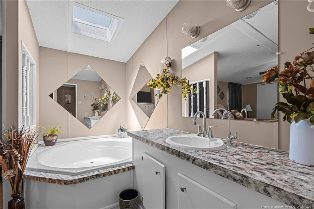 5236-5240 Maxwell Road Stedman, NC 28391 - Photo 18 of 50 a bathroom with a granite countertop sink a mirror and vanity